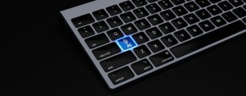 a black keyboard with a blue button on it